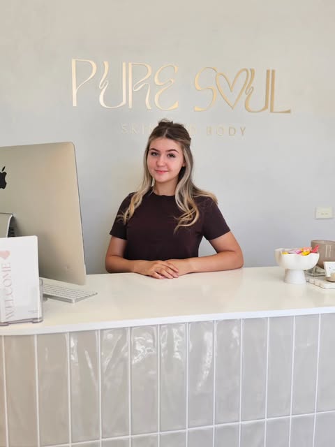 The white reception desk under the gold Pure Soul Skin + Body sign